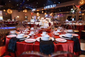 Elegant banquet table setup with red linens and floral centerpiece at Oasis Convention Centre